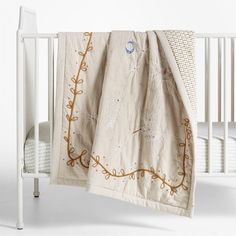 a white crib with a blanket on top of it