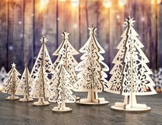 wooden christmas trees are lined up on a table