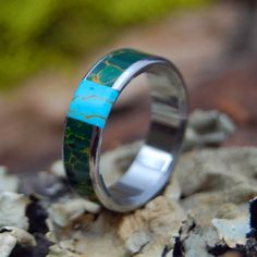 a ring that has been made to look like it is painted with turquoise and green