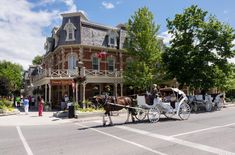 a horse drawn carriage on the street in front of a large building with many windows