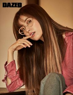 a woman with glasses on her head and long hair is sitting in front of a table