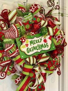 a christmas wreath on the front door with merry grinin's tag hanging from it