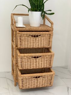 three wicker baskets stacked on top of each other with a plant in the middle