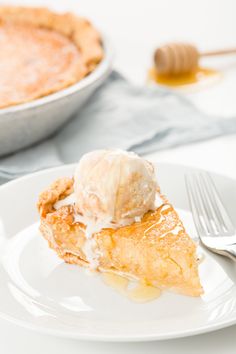 a piece of pie with ice cream on top is sitting on a plate next to a fork