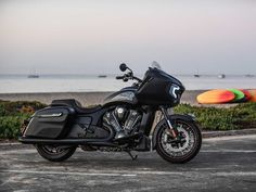 a black motorcycle parked in front of the ocean