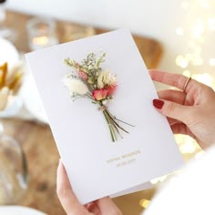 a woman holding a card with flowers on it