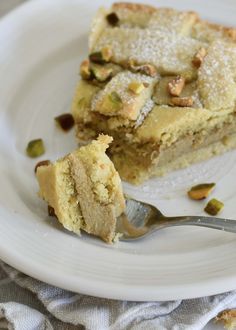 a piece of cake on a white plate with a fork next to it and a bite taken out