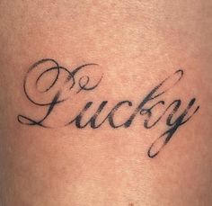 a close up of a person's stomach with the word lucky tattooed on it