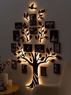 a family tree with pictures on the wall and lights in the shape of birds above it