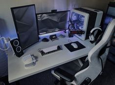 a desk with two computer monitors and headphones on it, next to a keyboard and mouse