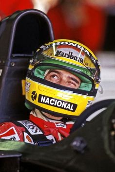 a man sitting in a racing car wearing a helmet