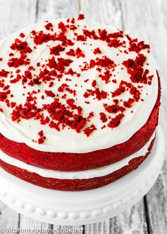 a red velvet cake with white frosting and sprinkles on a plate