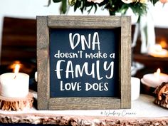 a chalkboard sign that says dona doesn't make a family love does with candles in the background