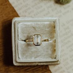 an engagement ring sits in a velvet box