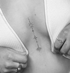 a woman's stomach has a star tattoo on it and is holding her hands behind her back