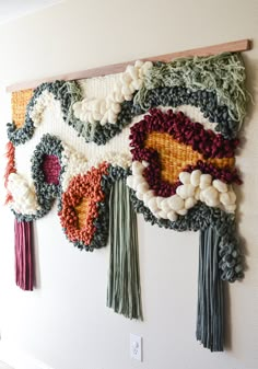 a wall hanging made out of yarn with tassels