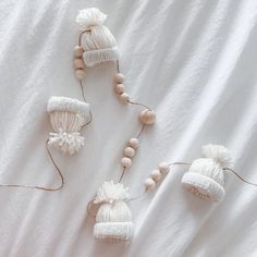 three knitted hats and beads on a white sheet