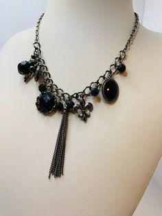 Black beaded charm necklace with key charm, heart charm, facetted beads, chains dangling. Antique silver tone metal chain. Measurements are 11 inches long by 1 inch wide with 2 3/4 inch extender chain. In good condition. Black Pendant Charm Necklace With Chain, Elegant Black Charm Necklace, Black Dangle Necklace With Lobster Clasp, Black Jewelry With Dangling Charms For Gift, Black Metal Pendant Charm Necklace, Black Metal Dangle Chain Necklace, Black Pendant Chain Necklace With Lobster Clasp, Black Pendant Necklace With Vintage Charm, Black Dangle Jewelry With Charms