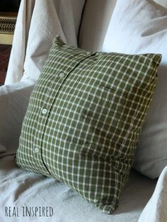 a green and white checkered pillow sitting on top of a couch next to pillows