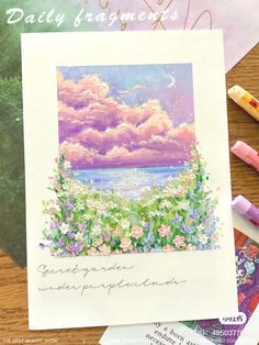 a card with flowers and clouds on it next to some crayons, markers and pencils