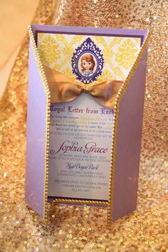 the inside of a purple and gold wedding card with a bow on it's front