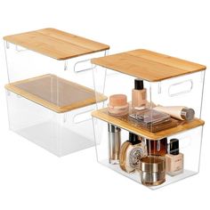 two clear storage containers with wooden lids on each side and one containing various beauty products