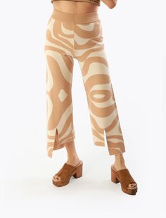 The only thing we love more than the pattern on these pants is their playful slit hem. This versatile design anchors our entire Rumba collection. From the Aja to the Ryu V, your styling options are plentiful! Capri pant with elastic waistband and hi/lo cutout slit accents in double knit abstract swirl pattern. #M3838 Love More, Double Knit, Swirl Pattern, Meet The Team, Double Knitting, Anchors, Black Pants, Swirl, Capri Pants