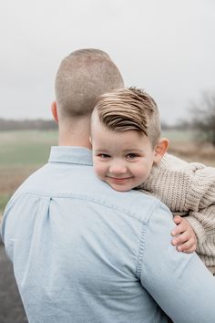 a man holding a little boy in his arms