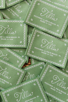 many green business cards with white writing are stacked on top of each other in a pile