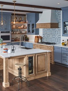 a kitchen with blue cabinets and white counter tops, an island in the middle is surrounded by stools