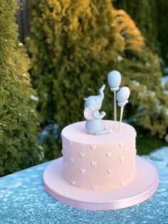 a pink and blue cake sitting on top of a table covered in frosted decorations