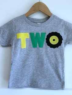 a gray t - shirt with the word two printed on it and a black tractor