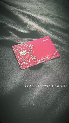 a pink card sitting on top of a black cloth