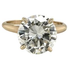 an engagement ring with a round diamond in the center and two tone gold bands around it