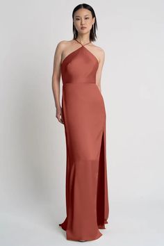 a woman in a long pink dress with an asymmetrical neckline and side slit