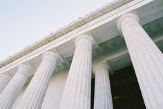 an old building with three large columns and two clocks