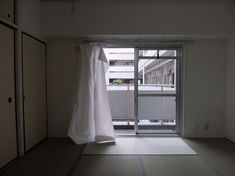 an empty room with sliding glass doors and white curtains