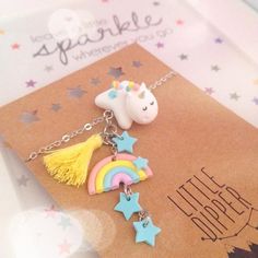 a unicorn necklace with stars, a rainbow and a tassel