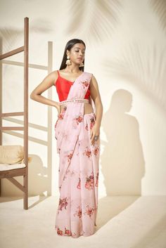 This georgette saree with printed florals is paired with a red tusar silk blouse.  The blouse has a back cut out with a hook opening. Includes the inner skirt. Mrunalini Rao, Floral Sarees, Peach Saree, Floral Print Sarees, Yellow Lehenga, Modern Saree, Saree Blouse Patterns, Simple Sarees, Trendy Blouse