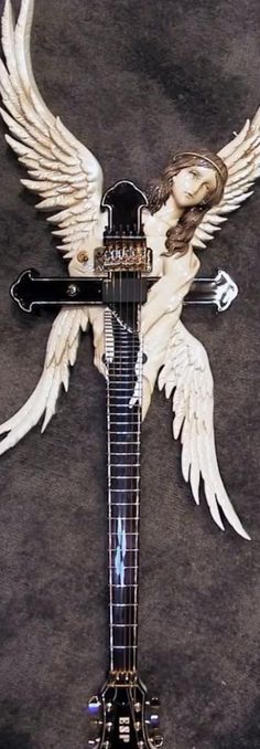 an electric guitar with angel wings on it's body, and a cross in the middle