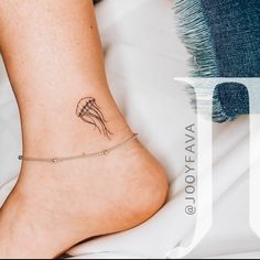 a woman's foot with a small tattoo on the left side of her ankle