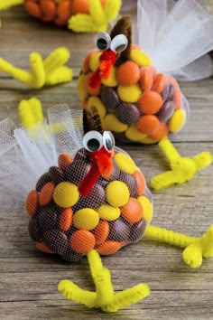 two turkeys made out of candy sitting on top of a wooden table