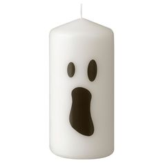 a white candle with a black face on it's side and eyes in the middle