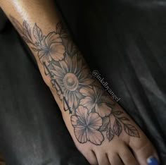 a woman's foot with flowers and leaves on it