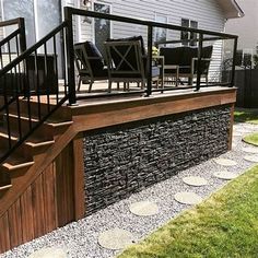 an outdoor deck with stone steps and railing