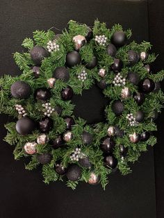 a christmas wreath with black and silver ornaments