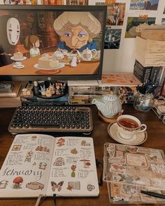 an open book sitting on top of a wooden desk next to a computer monitor and keyboard