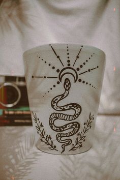 a white cup with a snake drawn on it