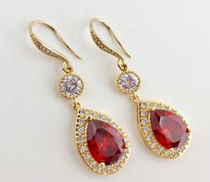 I've created these luxury red ruby cubic zirconia bridal teardrop earrings in gold plated brass setting. Earrings feature a large teardrop with pear cut red ruby cubic zirconia center surrounded by tiny round zirconia crystals. Teardrop dangles from a round cubic zirconia connector and zirconia detailed ear wire. Total length of the earrings is 5 cms For matching necklace click: https://www.etsy.com/listing/667778454/red-bridal-gold-necklace-red-crystal?ref=related-6 For earrings and necklace se Formal Red Cubic Zirconia Bridal Earrings, Red Pear-shaped Wedding Earrings, Red Ruby Earrings For Wedding, Red Ruby Wedding Earrings, Red Teardrop Earrings For Anniversary, Red Ruby Pear-shaped Earrings, Elegant Red Teardrop Bridal Earrings, Ruby Drop Earrings For Wedding, Red Ruby Bridal Earrings For Anniversary