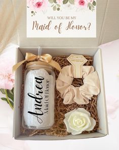 an open box with some flowers and a bottle in it that says will you be my maid of honor?